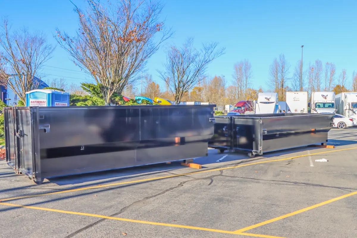 Professional dumpster rental service with roll-off container on residential driveway in West Clarkston-Highland